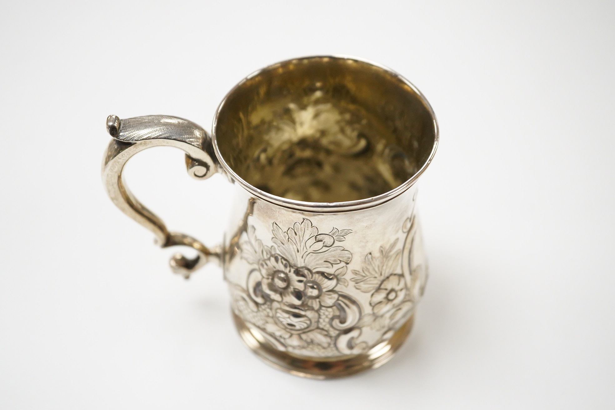 A George II silver baluster mug, by John Bayley, London, 1751, with later embossed decoration, height 95mm, 6.4oz.